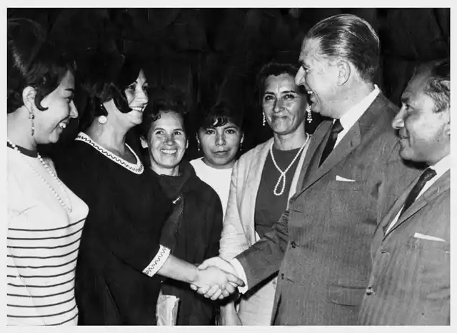 Situada en el centro, Hortencia Mercedes Díaz de Maco sonríe con evidente alegría mientras presencia el saludo entre una de las asistentes y el entonces presidente Fernando Belaúnde Terry. Foto: difusión Situada en el centro, Hortencia Mercedes Díaz de Maco sonríe con evidente alegría mientras presencia el saludo entre una de las asistentes y el entonces presidente Fernando Belaúnde Terry. Foto: difusión